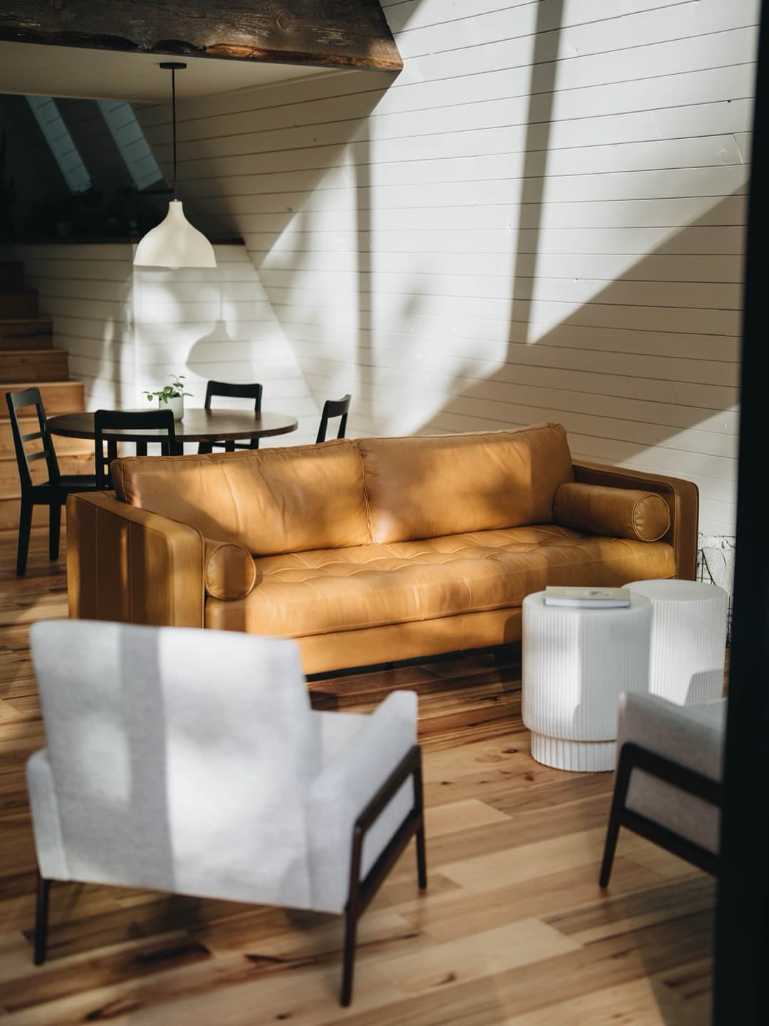 Bright interior living space with leather sofa and forest view